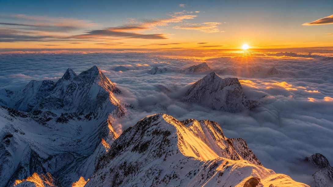 雪山之巅，云海翻涌，日出时分，金色阳光照在雪峰，壮观，广角
