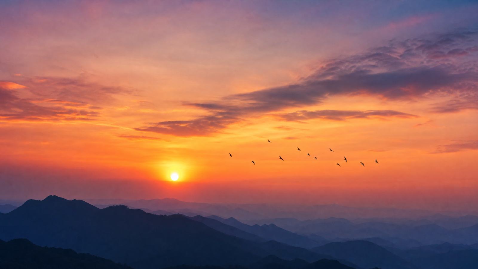 夕阳下的山峦剪影，天空呈现橙色与紫色渐变，远处有飞鸟，摄影风格，高清晰，16:9